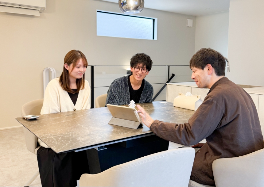 男性が、男性と女性と打ち合わせしている