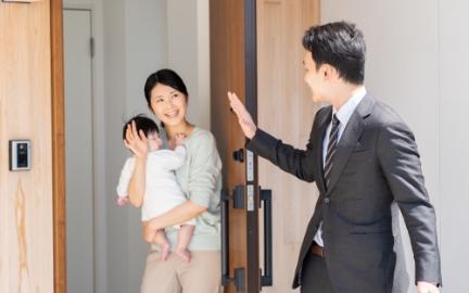 赤ちゃんを抱いているお母さんが手を降っている