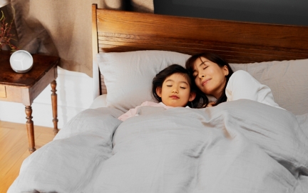 ベットで寝ている娘とお母さん