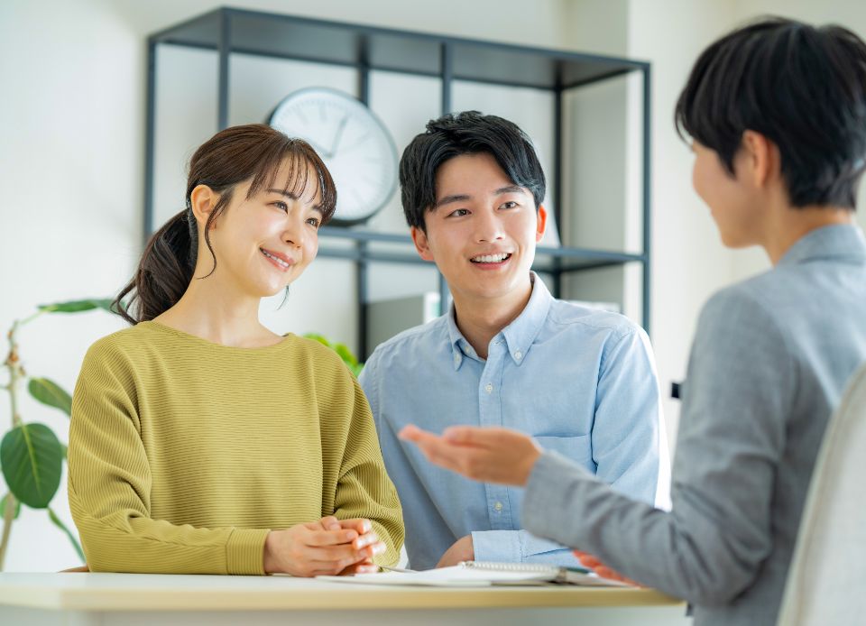 ソファで笑顔で相談する夫婦とスタッフ
